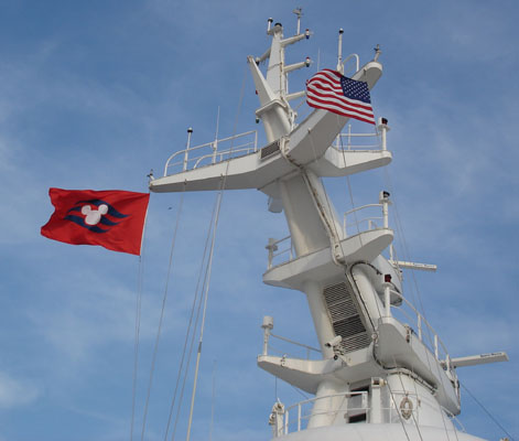 Flags of the Disney Cruise Line and of the United States of America flying atop the M/S Disney Magic